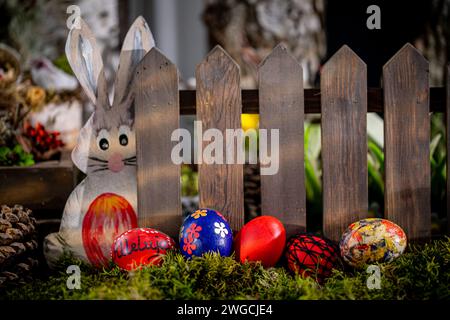 Whimsical Easter Scene: Handcrafted Eggs, Cute Bunny Cutout, and Rustic Fence Stock Photo