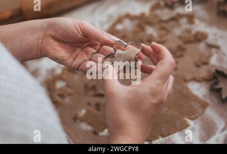 Close-up photo of hands holding gingerbread man cookie cutter and dough Stock Photo