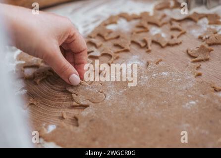 Close-up photo of hands holding gingerbread man cookie cutter and dough Stock Photo