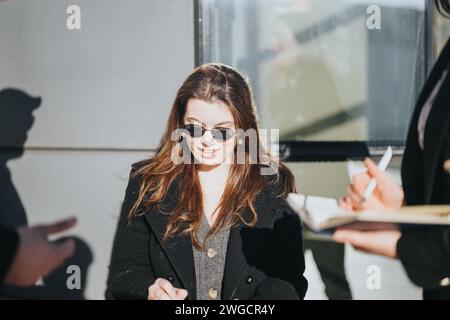 Two young professionals engaging in a collaborative discussion on a sunny day in an urban setting, depicting teamwork and entrepreneurship. Stock Photo