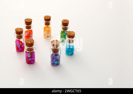 Glass bottles arranged in a circle each containing hearts of different colors Stock Photo