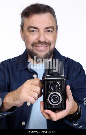 Photographer with an old retro camera isolated on a white background. Studio shot Stock Photo