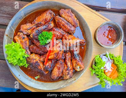 Grilled chicken wings in homemade Sriracha souce, topped with fresh microgreens Stock Photo