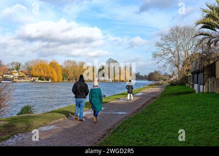 Walkers on the Thames footpath at Walton on Thames, on a sunny winters day Surrey England UK Stock Photo