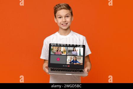 Cute boy teenager showing laptop with online lesson screen Stock Photo