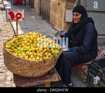 Egyptian woman selling lemons on Moez Street in Fatimid or Medieval Cairo, Egypt Stock Photo