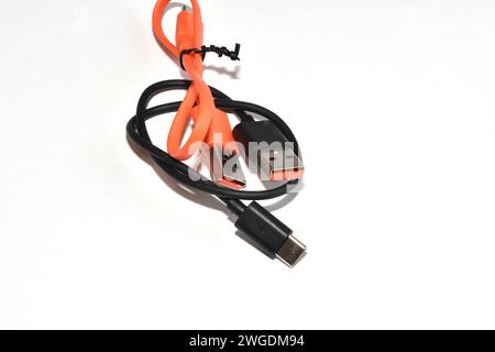 Two USB cables of different colors and sizes lie on a white background. Stock Photo