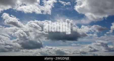 Panorama of fluffy cumulus clouds the darker patches and blue sky Stock Photo
