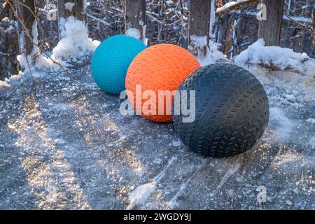 heavy slam balls filled with sand on an icy backyard deck, exercise and functional fitness concept Stock Photo