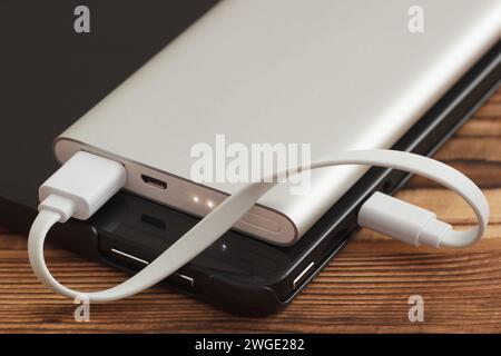 Tablet Pc Charging With The External Power Bank. Closeup Photo Of Cable Connected To Tablet And Power Bank. Stock Photo