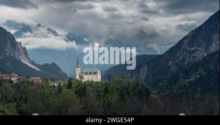 Panoramic view of moody landscape with small church in Dolomites mountains, Belluno, Veneto, Italy. Chiesa Parrocchiale di San Martino in Italian Alps Stock Photo