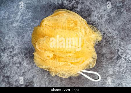 Yellow bath shower sponge puff . Overhead close up detail. Stock Photo
