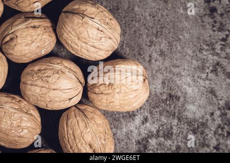 Whole walnuts in shells on dark background. Fresh organic nuts. Top overhead view. Whole walnuts in shells on dark background. Fresh organic nuts. Top Stock Photo