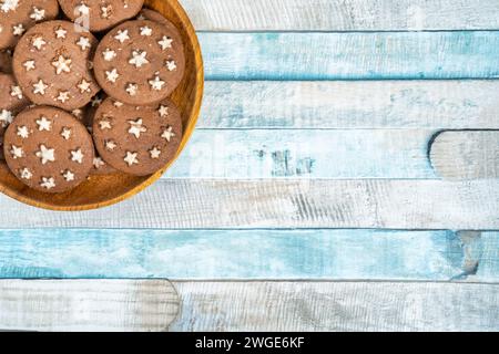 Delicious sweet cocoa cookies biscuits on a wooden plate . Overhead shot. Colorful blue background. Stock Photo