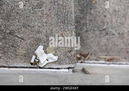 butch cigarette with a white paper on the stair floor. Selective focus and shallow depth of field. Stock Photo