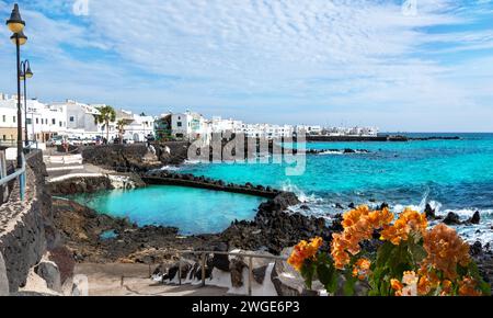 View of the coastline Punta Mujeres surrounded by black volcano stones and emeral water on a sunny day in Lanzarote island in the Canaries Stock Photo