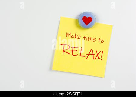 Magnet and yellow sticky note reminder to relax on refrigerator Stock Photo