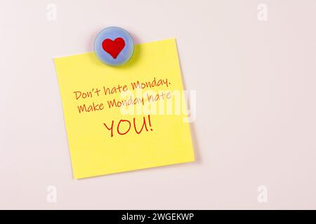 Magnet and yellow sticky note reminder to not hate Monday on refrigerator Stock Photo