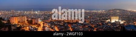 Barcelona's Urban Nightscape A View of City Lights and the Dusk Horizon. Stock Photo