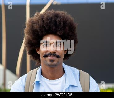 Portrait of a young African American man with afro hair looking at camera in a city Stock Photo