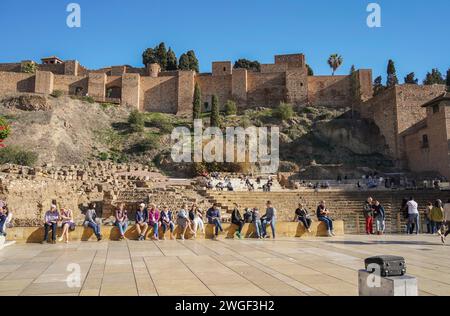 Malaga Spain. Visitors in front of Malaga Alcazaba. Ancient Roman amphitheater with Alcazaba castle behind, Malaga, Andalusia, Spain Stock Photo