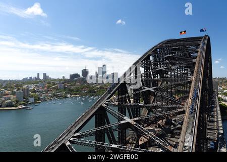 People climbing the Sydney Harbour Bridge viewed from the Pylon Lookout, across the Bridge's arch and looking out to North Sydney Stock Photo