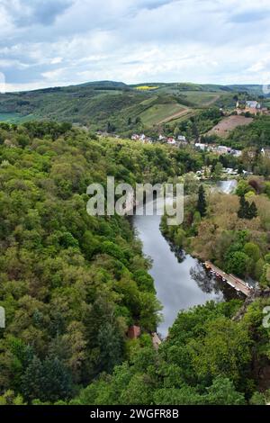 Bad Munster, Germany - May 12, 2021: Nahe River surrounded by green trees and hills with Rheingrafenstein Castle in the background on a spring day in Stock Photo
