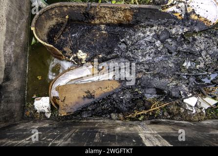 Burnt coffin wit0h flowers in cemetery, religion and burial Stock Photo