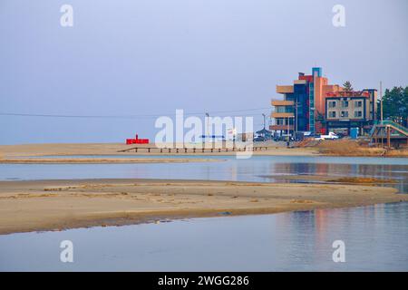 Samcheok City, South Korea - December 28, 2023: The entrance to Deokbong Mountain Coastal Ecological Trail at Deoksan Beach, marked by buildings and s Stock Photo