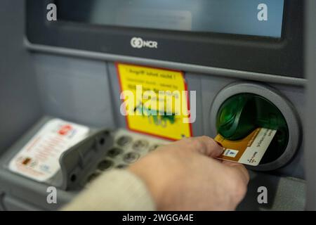 Frau hebt Geld am Geldautomaten ab 04.02.2024, Limburg: Symbolfoto, Illustrationsbild, Symbolbild, Illustrationsfoto Frau hebt Geld am Geldautomaten ab Ein Bild zeigt die Hand einer Frau, die gerade dabei ist, mit ihrer EC-Karte an einem Geldautomaten Geld abzuheben. Die fokussierte Aufnahme fängt den Moment ein, in dem die Karte in den Schlitz des Automaten eingeführt wird, symbolisch für den alltäglichen Vorgang des Geldabhebens. Limburg Hessen Germany *** Woman withdrawing money from an ATM 04 02 2024, Limburg Symbol photo, illustration image, symbol image, illustration photo Woman withdraw Stock Photo