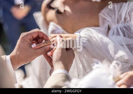 Detail of groom putting a ring on a finger of the bride. Stock Photo