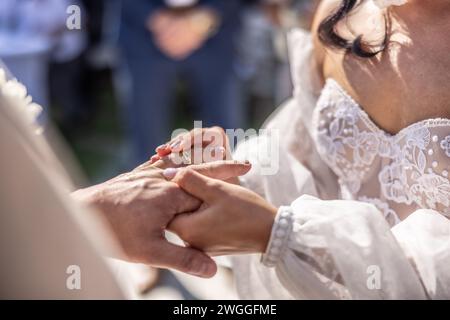 Wedding rings exchange with bride putting a ring on her future husband's finger. Stock Photo