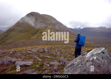 Man (Hiker) Standing on the Ridge to the Summit of the Scottish Mountain Corbett 'Beinn an Eoin' Flowerdale Forest, Wester Ross, North West Highlands. Stock Photo