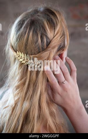 A closeup of a blonde girl against a brick wall Stock Photo