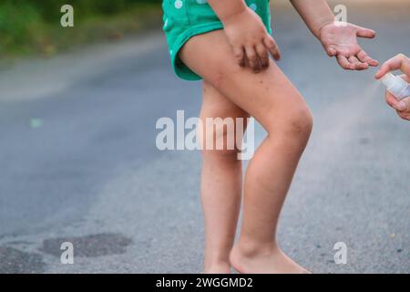 Mom sprays her child with mosquito repellent. Selective focus. Stock Photo