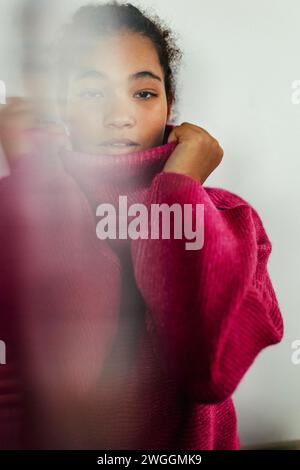 Portrait of beautiful curvy woman holding collar of turtleneck sweater, looking at camera. Stock Photo