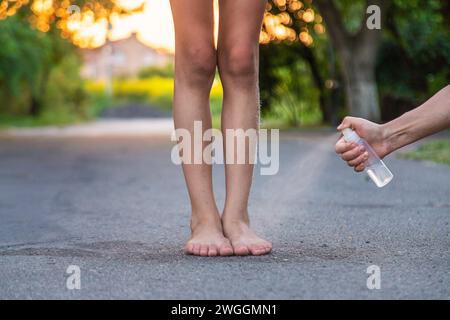 Mom sprays her child with mosquito repellent. Selective focus. Stock Photo