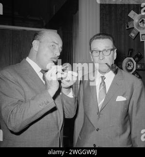 November 2, 1966. Amsterdam, Netherlands.  The Belgian author Georges Simenon (right) in Amsterdam, meeting Dutch actor Jan Teulings (left) at the statue of Maigret in the Amstel hotel. Jan Teulings was the Dutch personification of Inspector Maigret in the television series of the same name. Stock Photo