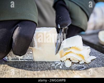 Close up of person cutting cheese, Allagash Wilderness Waterway, Maine, USA Stock Photo