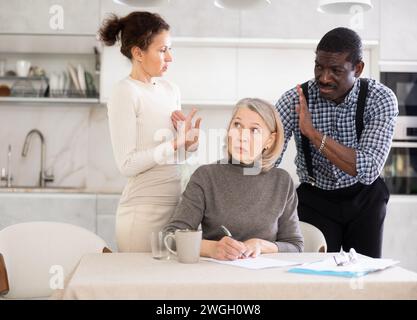 Couple discussing testament with elderly woman Stock Photo