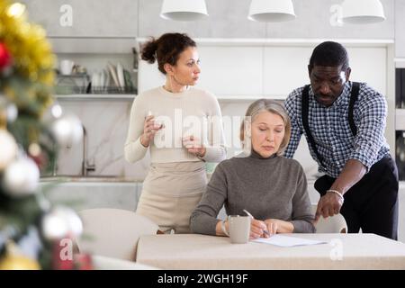 Couple discussing testament with elderly woman Stock Photo