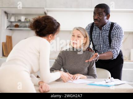 Couple discussing testament with elderly woman Stock Photo