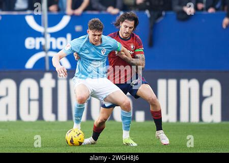 Jorgen Strand Larsen of RC Celta duels for the ball with Juan Cruz of CA Osasuna during the LaLiga EA Sports match between CA Osasuna and RC Celta at Stock Photo