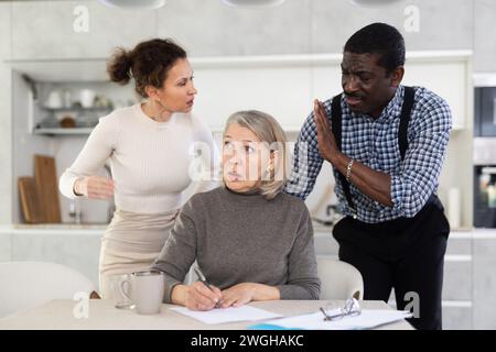 Couple discussing testament with elderly woman Stock Photo