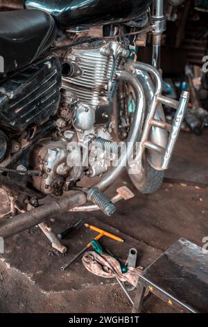 A old motorcycle being repaired in a garage. Stock Photo