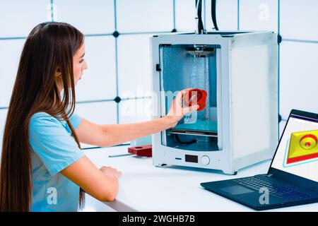Engineer prints a prototype model on a 3d printer in a laboratory using equipment. The concept of creativity, technology and 3d printing. Stock Photo