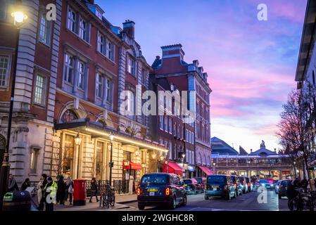 Covent Garden with pink sky, London taxis and people walking, , London, England, UK Stock Photo