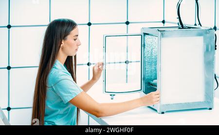 young woman working on a 3D printer Stock Photo