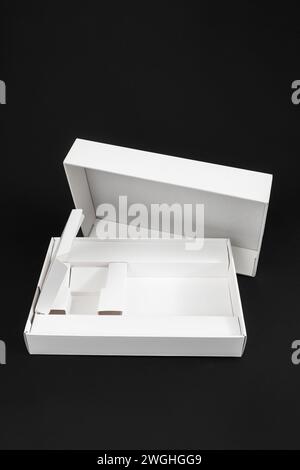 Empty smartphone or tablet box, white cardboard packaging isolated on black Stock Photo