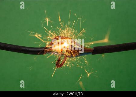 Sparks explosion between electrical cables, on green background, fire hazard concept Stock Photo